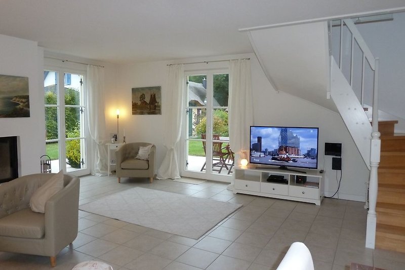Geräumiges Wohn- & Essbereich mit grossem Smart-TV und Kamin
