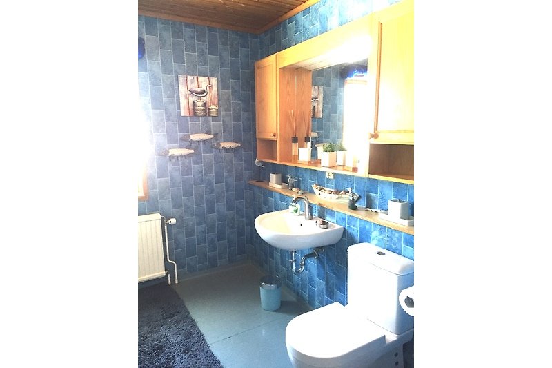 Badezimmer mit blauem und lila Waschbecken, Spiegel und Armaturen.