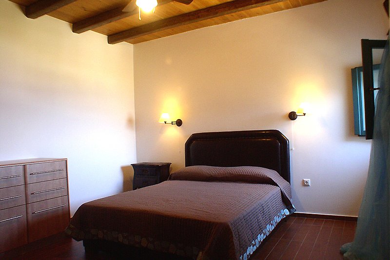 Gemütliches Schlafzimmer mit Holzmöbeln und gemütlicher Beleuchtung.