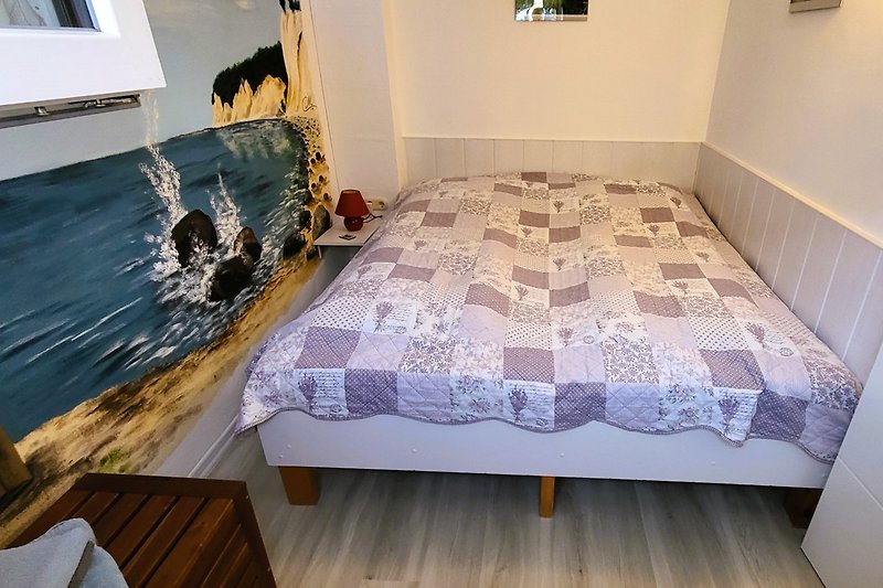 Schlafzimmer mit gemütlichem Bett und Holzmöbeln. Gemütliche Atmosphäre.