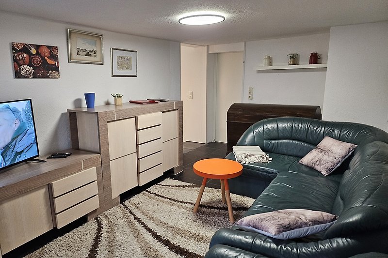 Gemütliches Wohnzimmer mit Holzmöbeln, Couch und Beleuchtung.