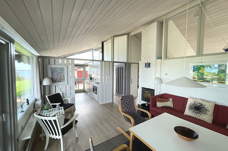 Das Wohnzimmer mit offenem Zugang zur Küche. Die grossen Fenstern sorgen für viel natürlichem Licht in den Räumen