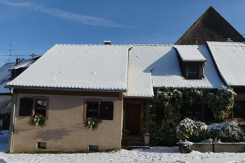Gemütliches Ferienhaus mit winterlicher Landschaft und charmantem Holzhaus.