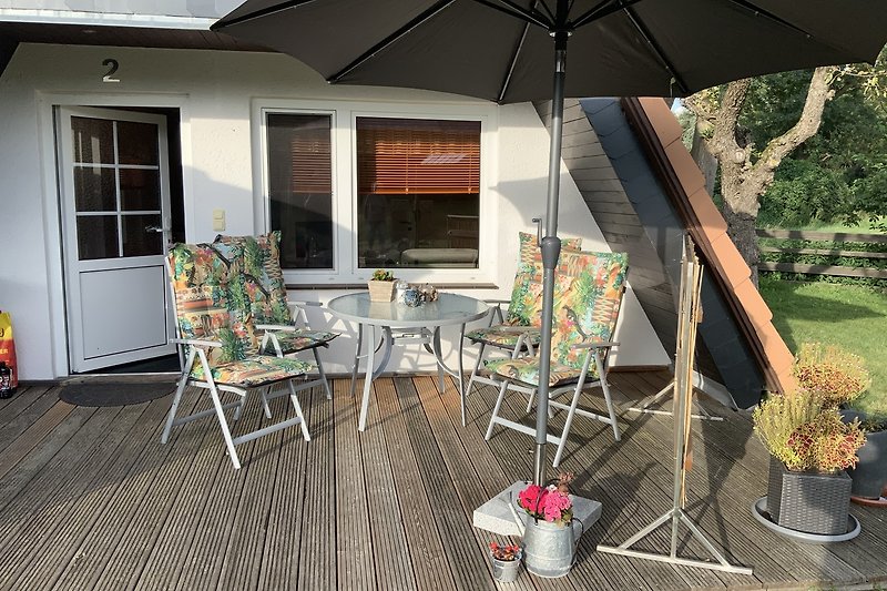 Terrasse mit Gartenmöbeln und zwei Sonnenschirmen