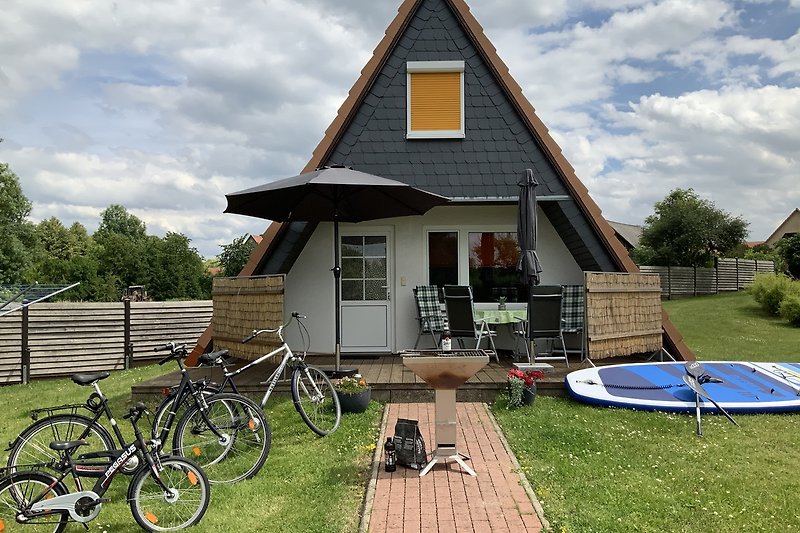 Terrasse mit Gartenmöbeln, Grill, Sonnenschirm und Windschutz