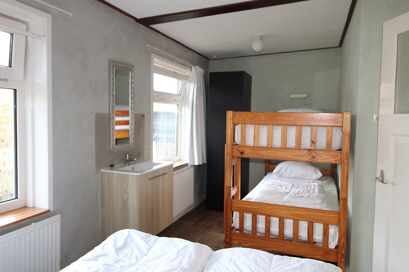 Gemütliches Schlafzimmer mit bequemem Bett und Holzmöbeln.