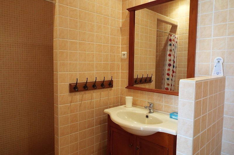 Gemütliches Badezimmer mit Holzdetails, lila Akzenten und Spiegel.