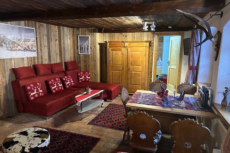 Gemütliches Wohnzimmer mit klassischer Einrichtung und Holzboden. Bequemes Sofa, Tisch und Lampe.