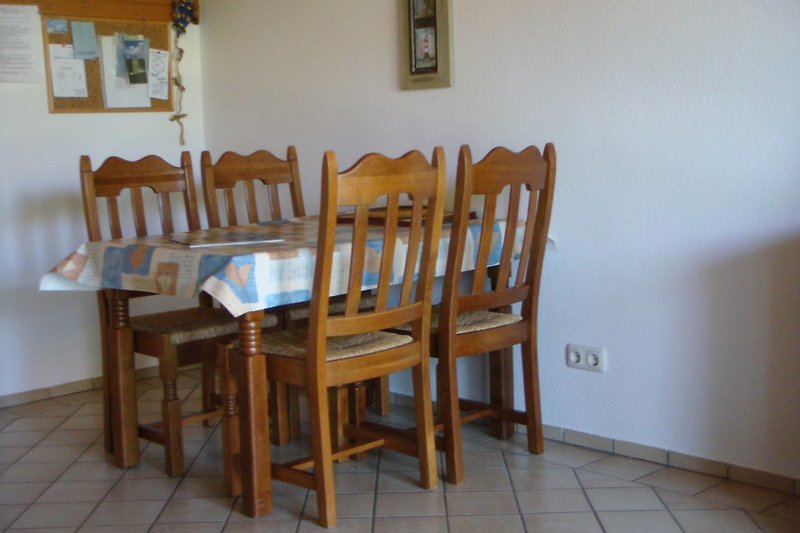 Holztisch mit Stühlen in Küche.
