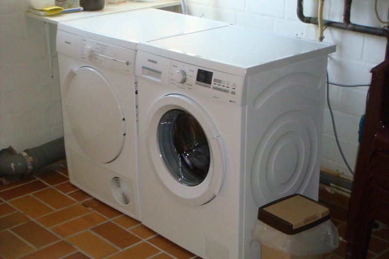 Waschmaschine und Trockner in der Waschküche.