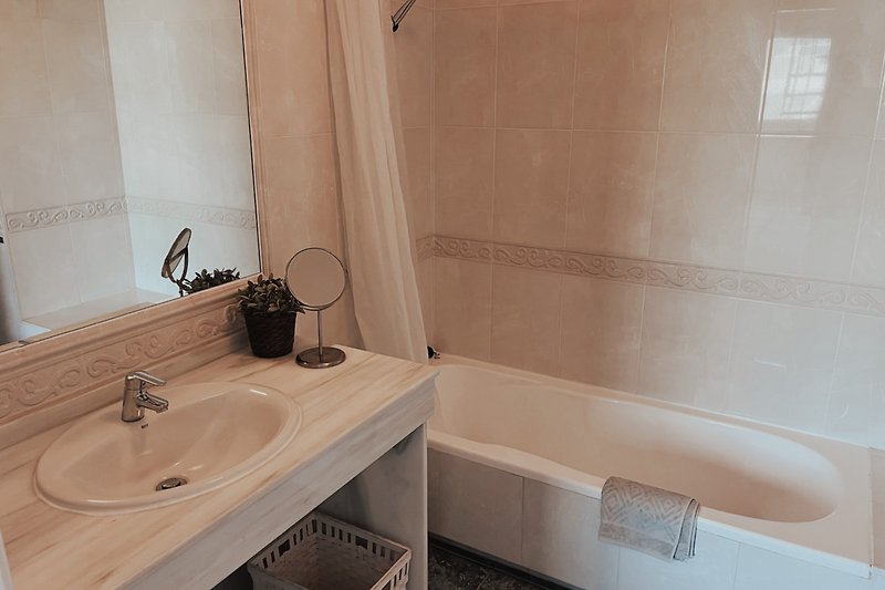 Ein stilvolles Badezimmer mit einer Badewanne, einem Spiegel und eine Badewanne.