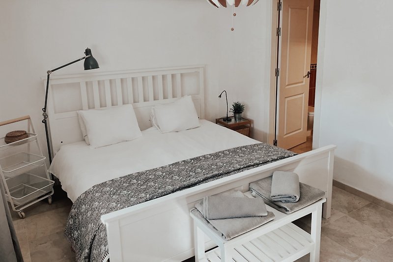 Gemütliches Schlafzimmer mit stilvollem Bett und elegantem Interieur und Badezimmer