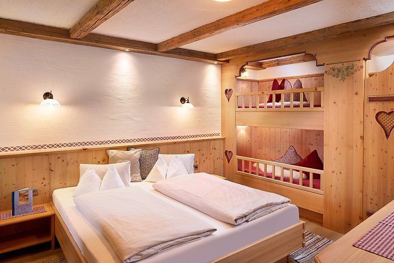 Gemütliches Schlafzimmer mit Doppelbett und Stockbett