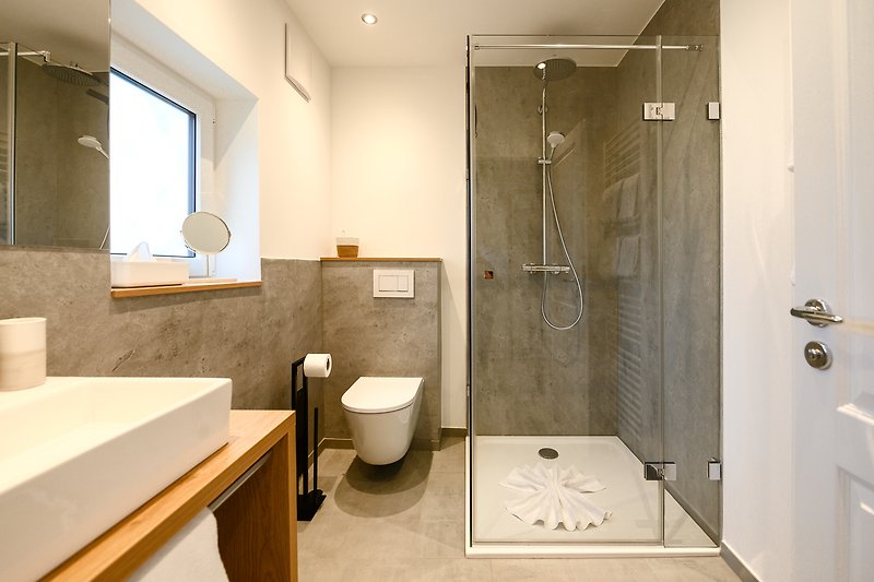 Schönes Badezimmer mit Spiegel, Waschbecken und Dusche.