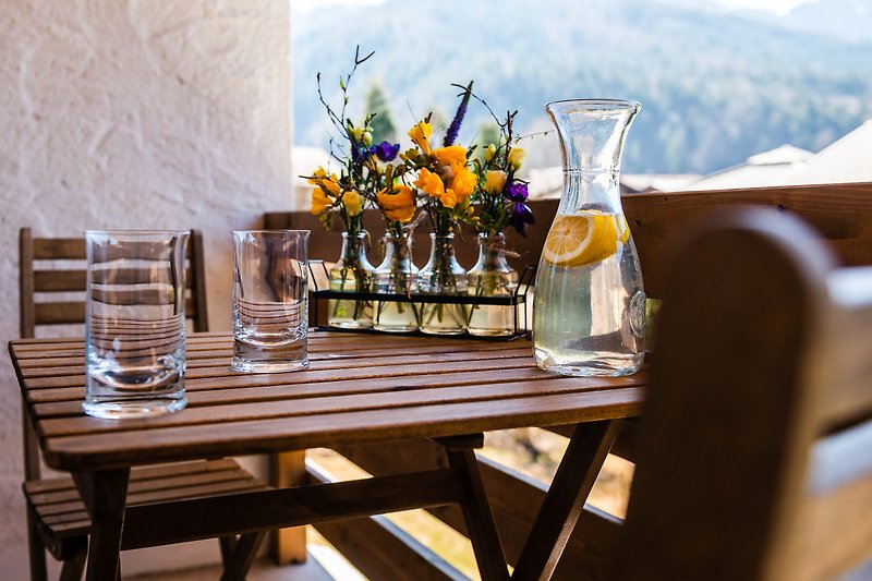 Schöne Tischdekoration mit Blumen, Geschirr und Gläsern.