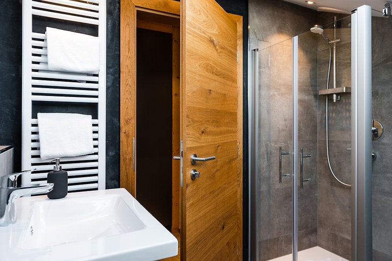 Schöne Dusche mit Holztür und Metallgriff.