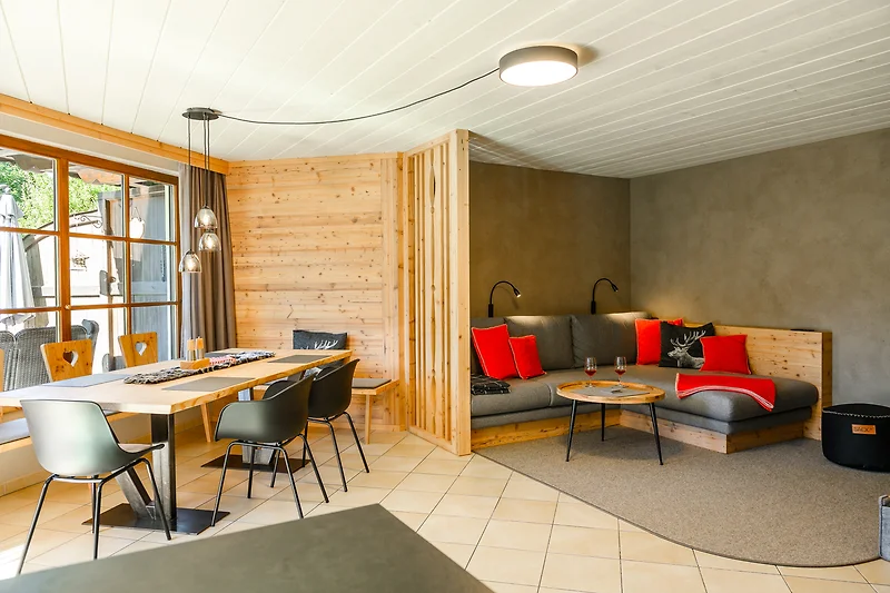 Gezellige woonkamer met comfortabele bank, houten meubels en stijlvolle lampverlichting.