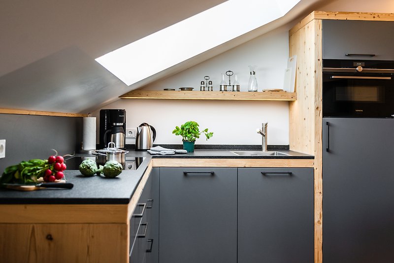 Moderne Küche mit Holzschränken, Arbeitsplatte und stilvoller Einrichtung.