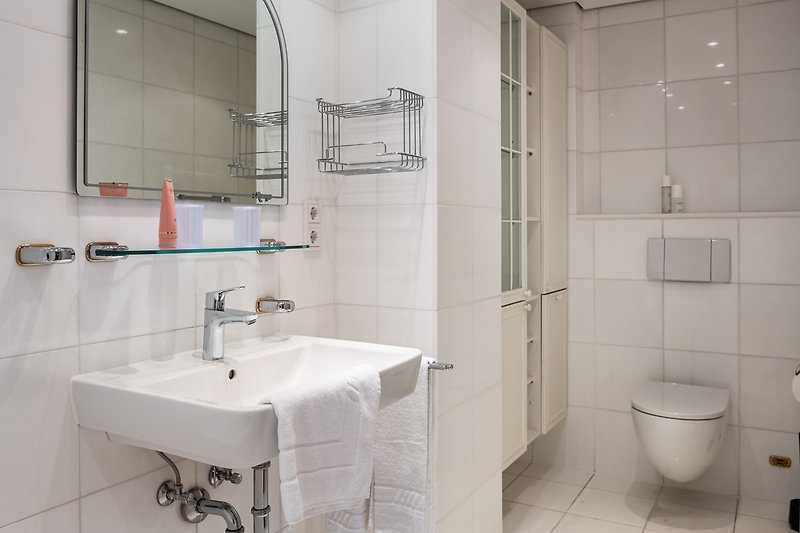 Ein stilvolles Badezimmer mit Spiegel, Waschbecken und Armaturen.