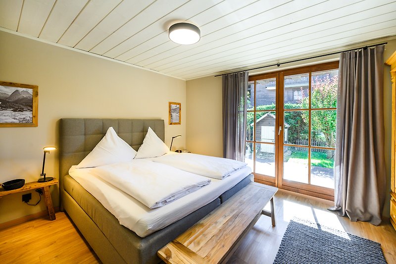 Gemütliches Schlafzimmer mit Doppelbett und Zugang zur Terrasse