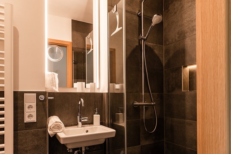 Kleines Badezimmer mit Spiegel, Waschbecken und Dusche