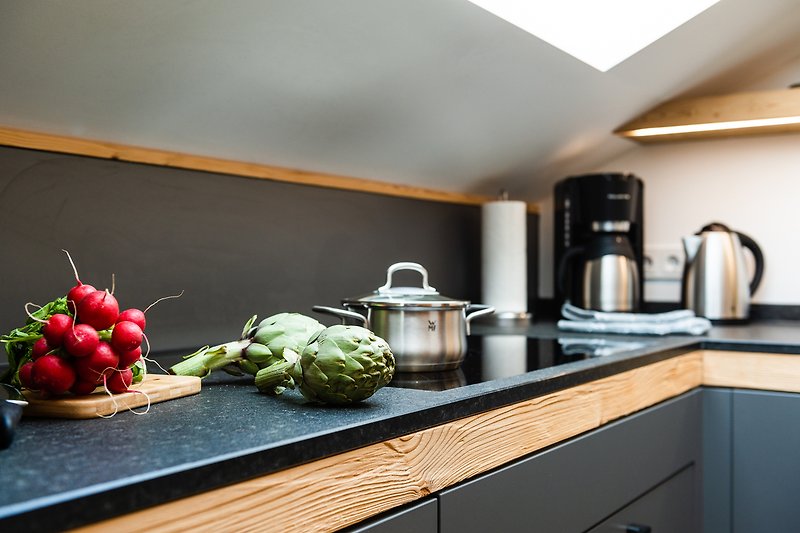 Eine moderne Küche mit Holzschränken, Arbeitsplatte und Küchengeräten.