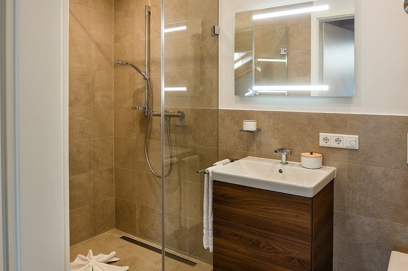 Moderne Badezimmer mit Spiegel, Waschbecken und Dusche.