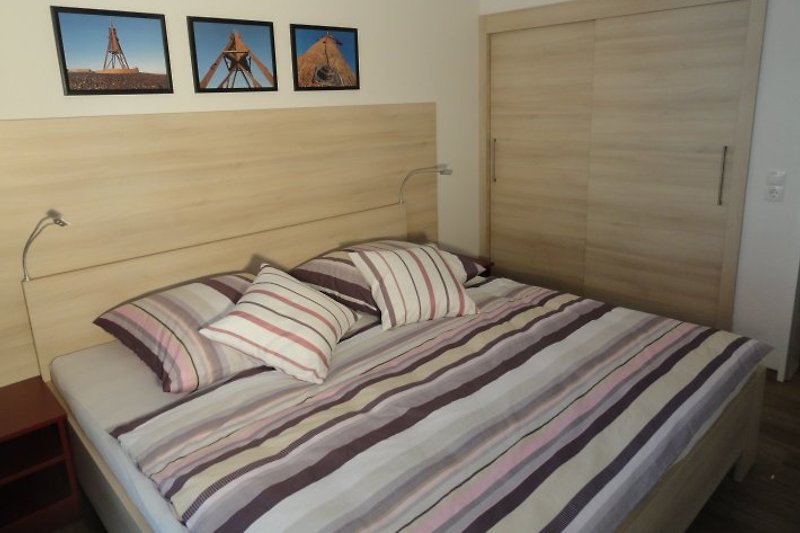 Schlafzimmer mit Doppelbett und großem Schiebetürenschrank