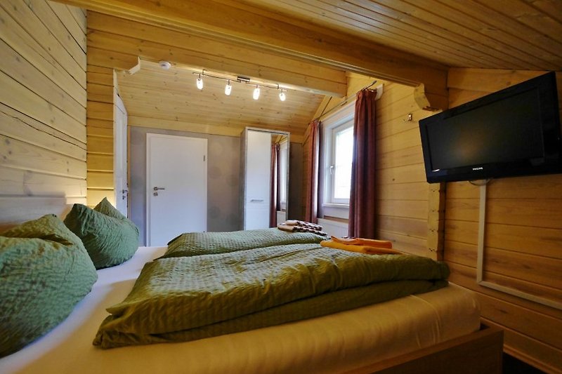 Schlafzimmer mit Doppelbett und TV im OG