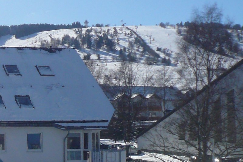 Fewo A**** - Wohnzimmeraussicht auf Skigebiet und Seilbahn