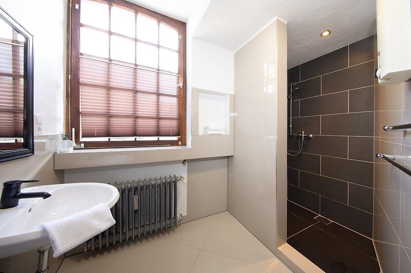 Modernes Badezimmer mit Holzakzenten und stilvoller Beleuchtung.