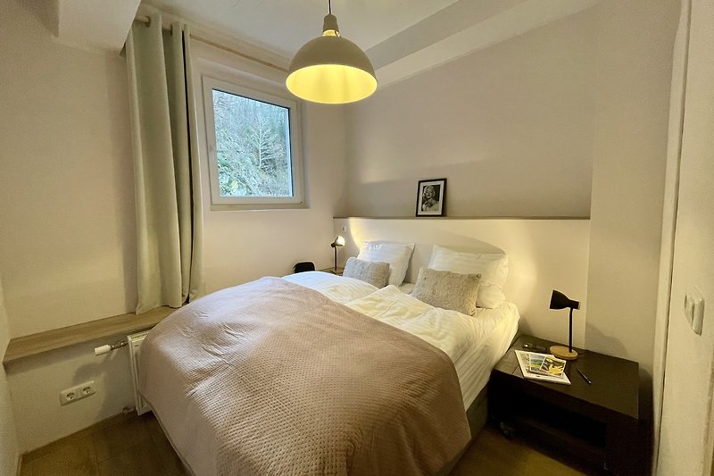 Elegantes Schlafzimmer mit stilvollem Bett und gemütlicher Beleuchtung.