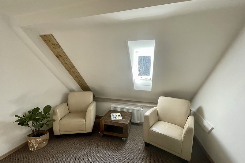 Stilvolles Wohnzimmer mit bequemer Couch, Holzmöbeln und Pflanze.