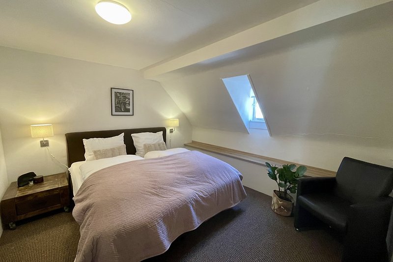 Stilvolles Schlafzimmer mit elegantem Bett und gemütlicher Beleuchtung.