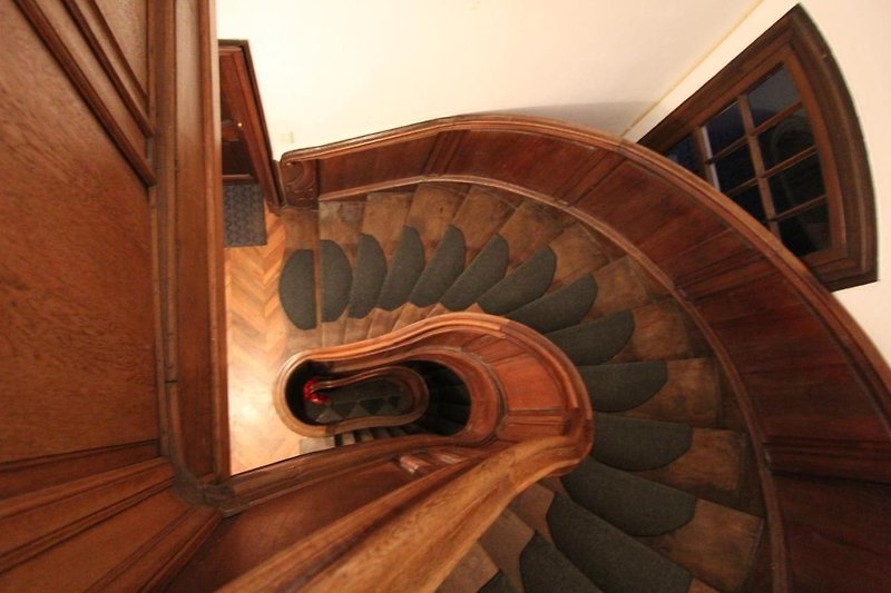 Spirale Treppe in Holzhaus mit Kunst und Fenster.