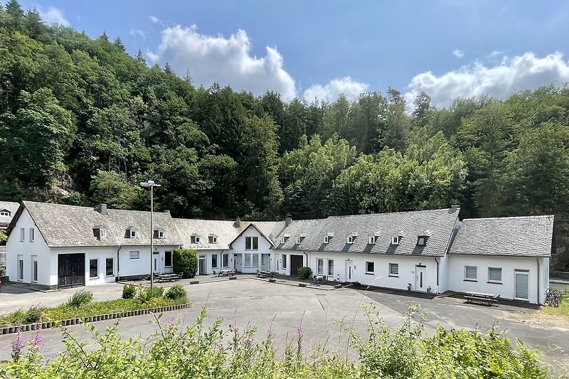 Hügeliges Grundstück mit Haus, Fenstern und grüner Landschaft.