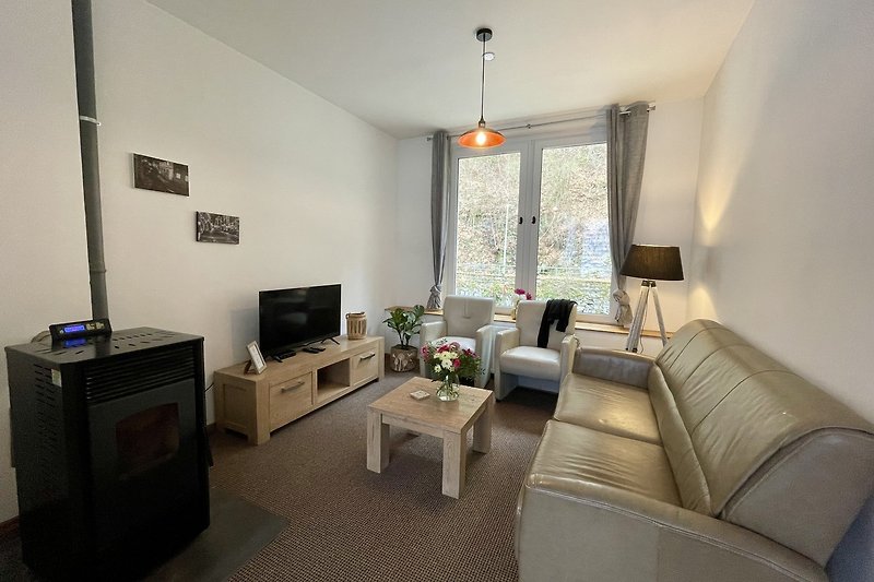 Modernes Wohnzimmer mit bequemer Couch, stilvollem Tisch, Pflanze und eleganter Einrichtung.