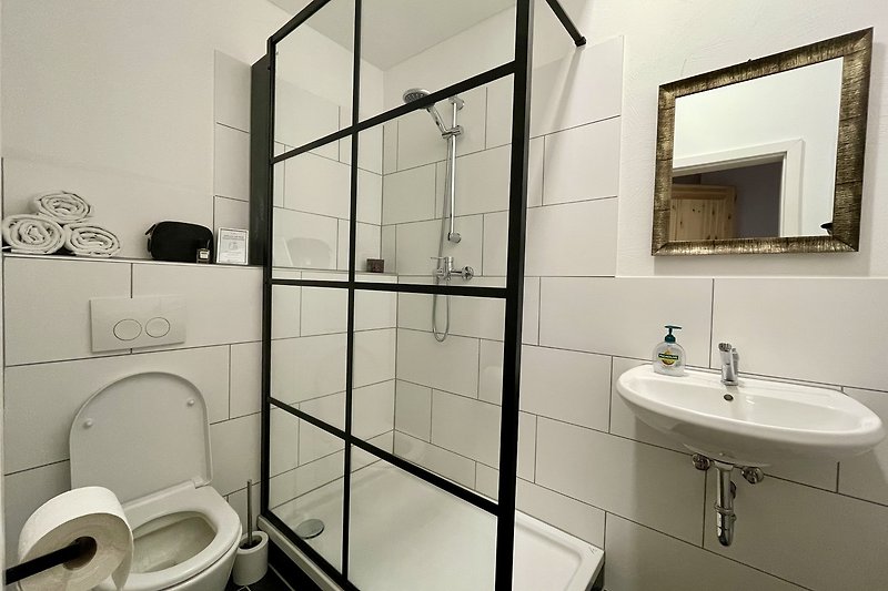 Modernes Badezimmer mit weißem Waschbecken und Dusche.