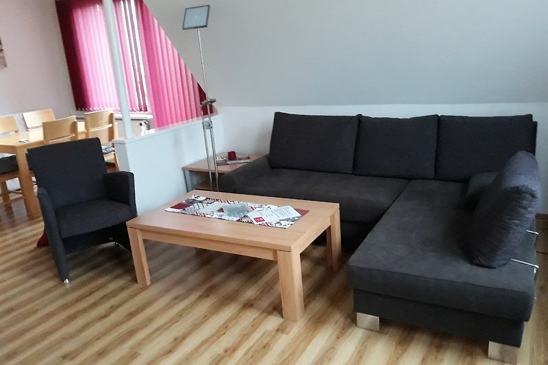 Gemütliches Wohnzimmer mit bequemer (Schlaf-)Couch