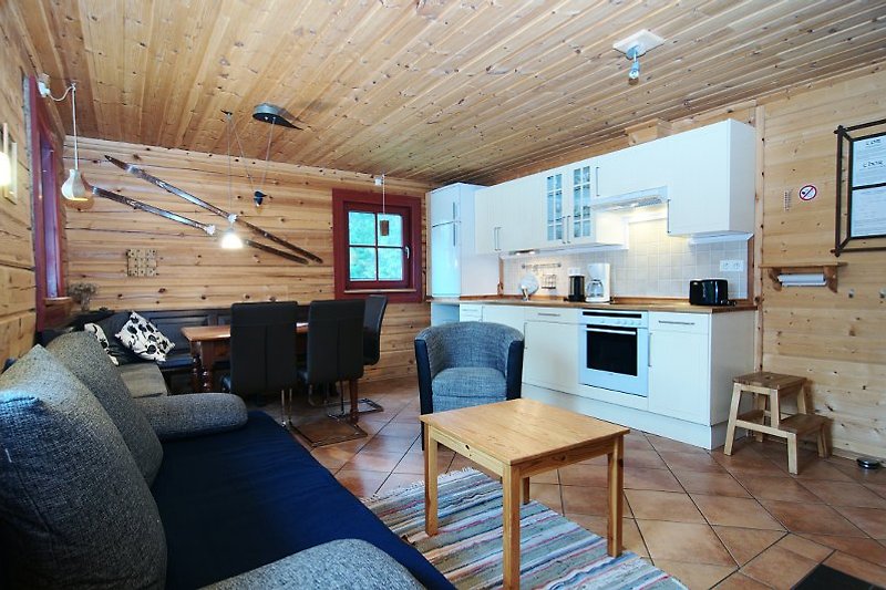 Wohnzimmer im Blockhaus mit Essecke und moderner Küche