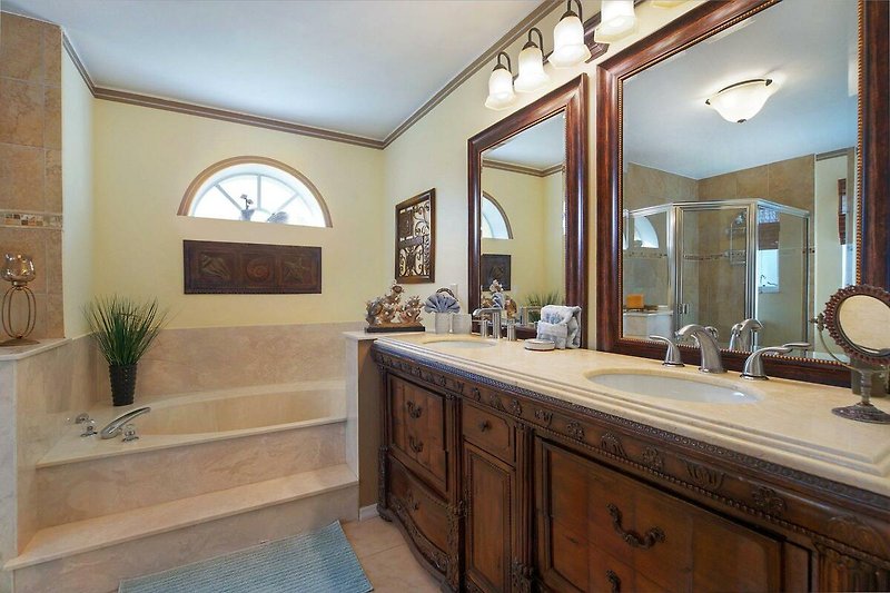 Schönes Badezimmer mit Spiegel, Pflanze und Waschbecken.