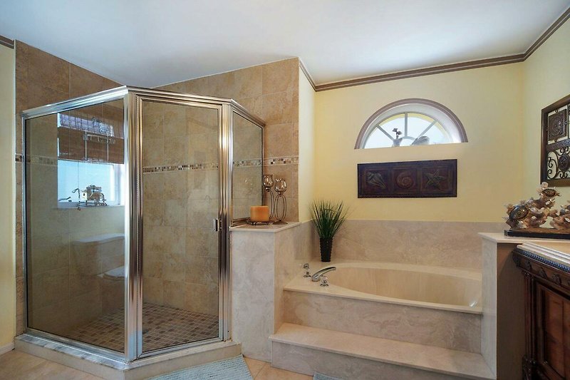 Schönes Badezimmer mit Holzboden, Badewanne und Dusche.