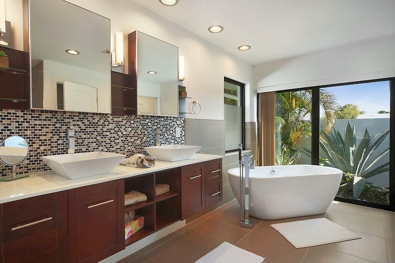Schönes Badezimmer mit stilvollem Spiegel, Waschtisch und Holzschrank.