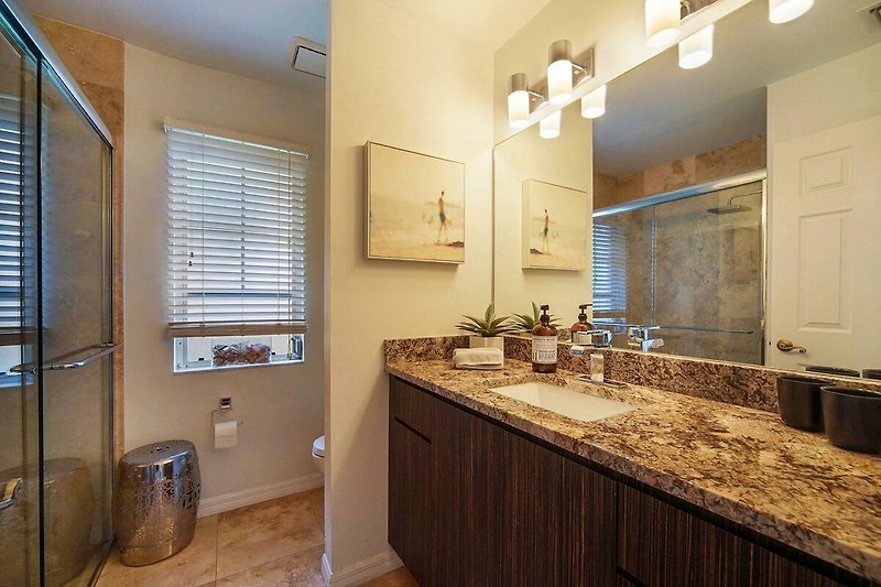 Schönes Badezimmer mit Spiegel, Waschbecken und Holzschrank.