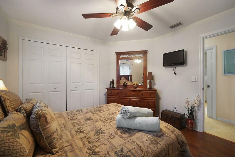 Gemütliches Schlafzimmer mit Holzmöbeln und Fensterbehandlung.