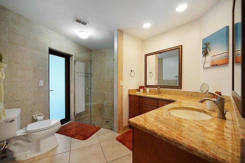 Schönes Badezimmer mit elegantem Spiegel, Waschtisch und Holzschrank.