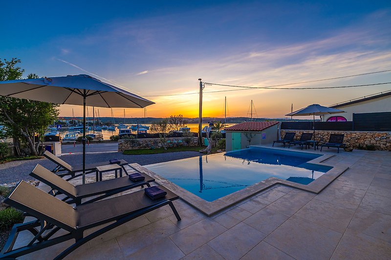 Luxuriöses Strandresort mit Pool, Palmen und Meerblick.