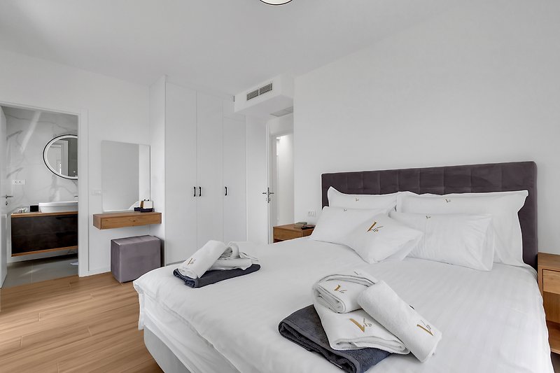 Gemütliches Schlafzimmer mit stilvollem Interieur und grauen Textilien.
