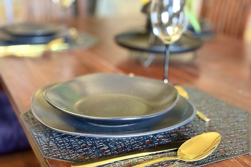 Elegantes Geschirr und Besteck auf Holztisch mit Porzellan und Glas.