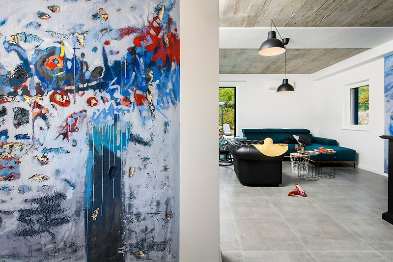 Gemütliches Wohnzimmer mit moderner Kunst, bequemer Couch und stilvoller Wanddekoration.
